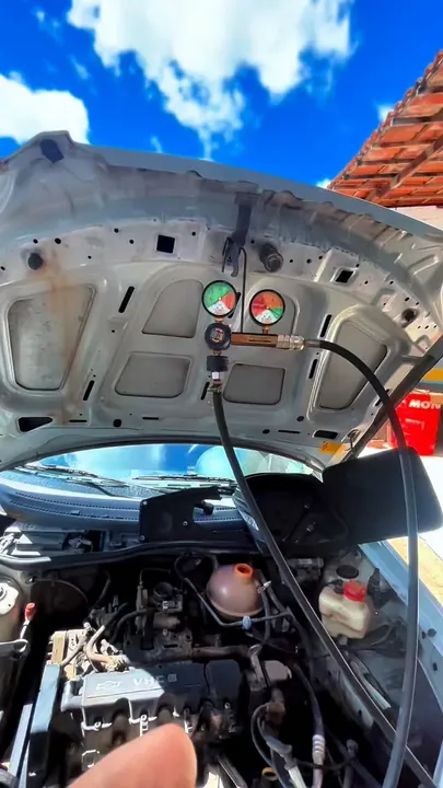 Capô aberto com manômetros conectados para teste no motor